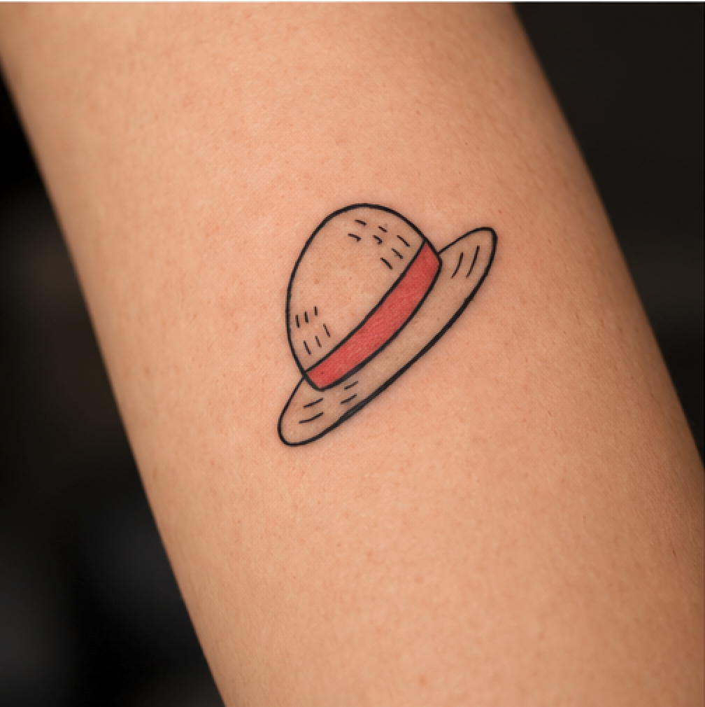Tatuaggio fineline Cappello di One Piece eseguito a linee sottili e precise da Mario Corallo a Milano